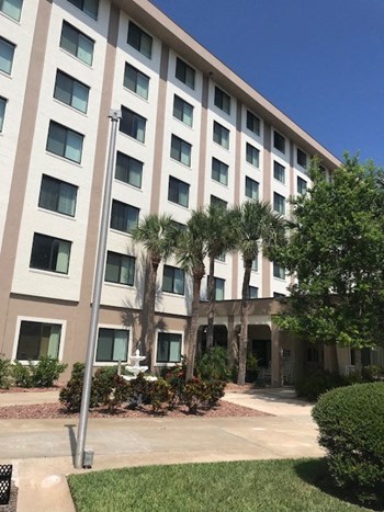 outside2 central manor apartments exterior with lush landscaping - Photo Gallery 4