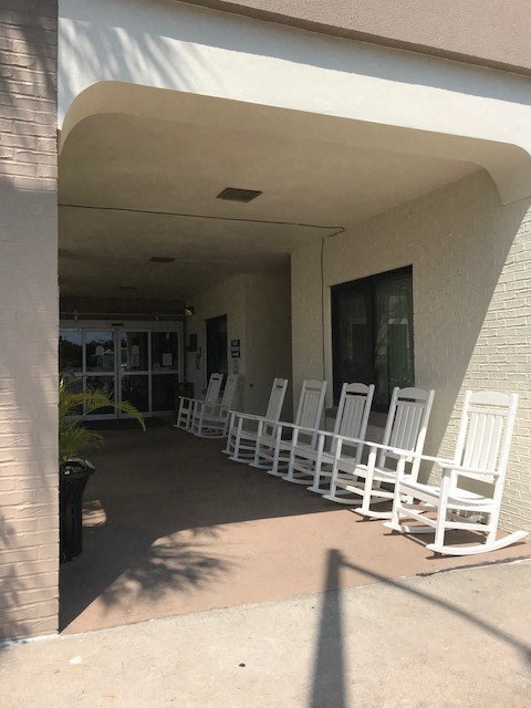 bank of rocking chairs under covered front entrance
