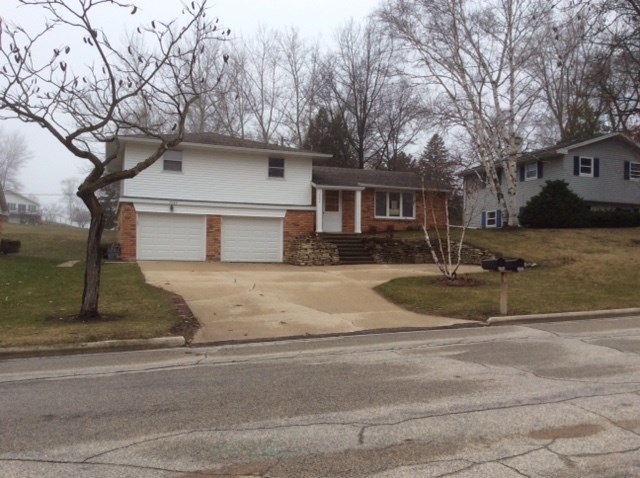 a house on the corner of a street with a driveway
