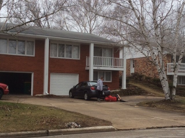 a man standing next to a car in front of a house