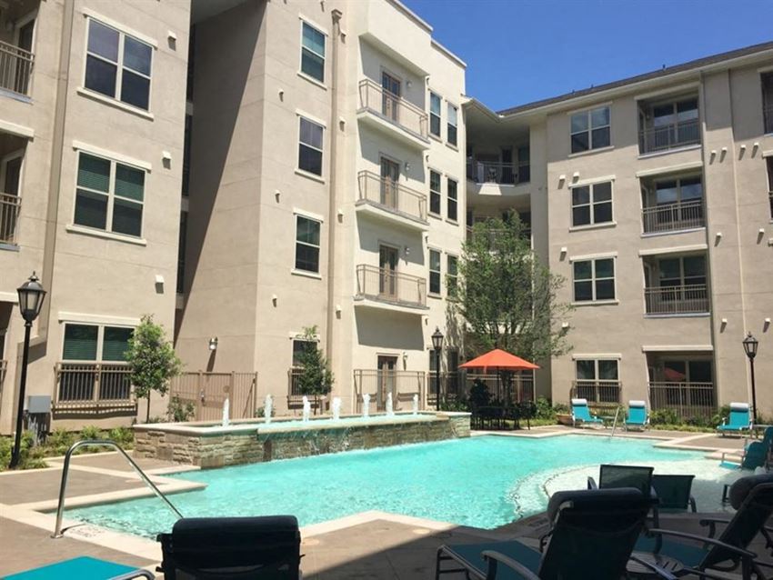 an apartment swimming pool in front of an apartment building