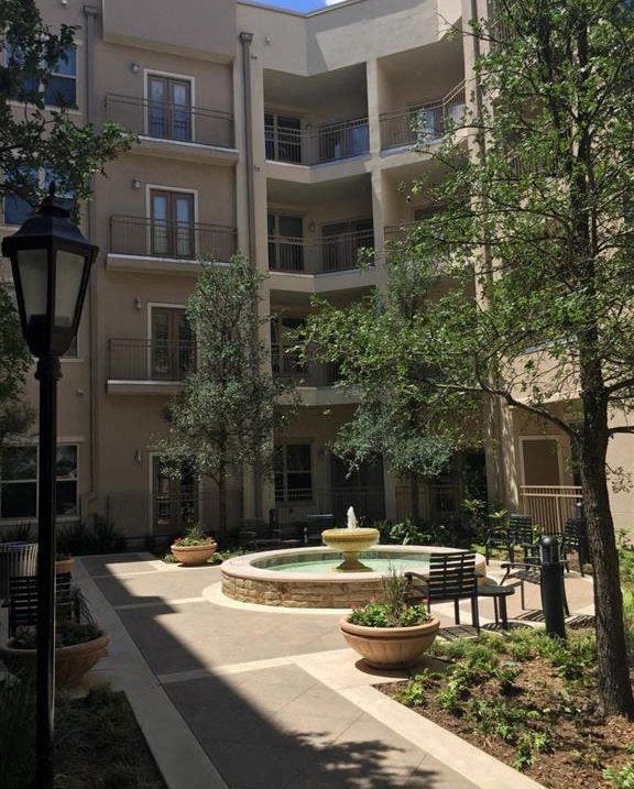 a courtyard with a fountain in front of an apartment building