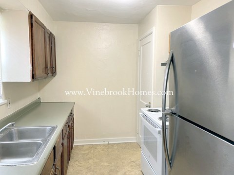 A kitchen with a stainless steel refrigerator and a sink.