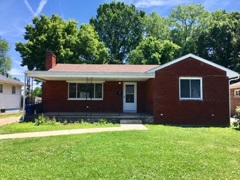 a red brick house with a lawn in front