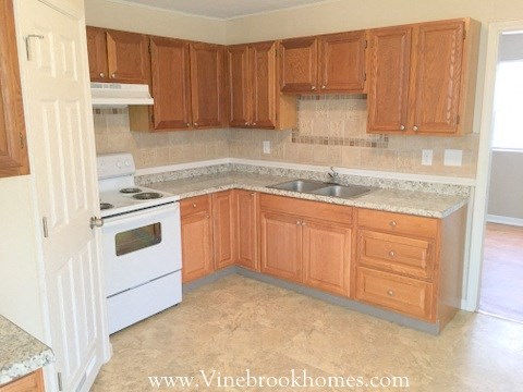 a kitchen with wooden cabinets and a stove and a sink