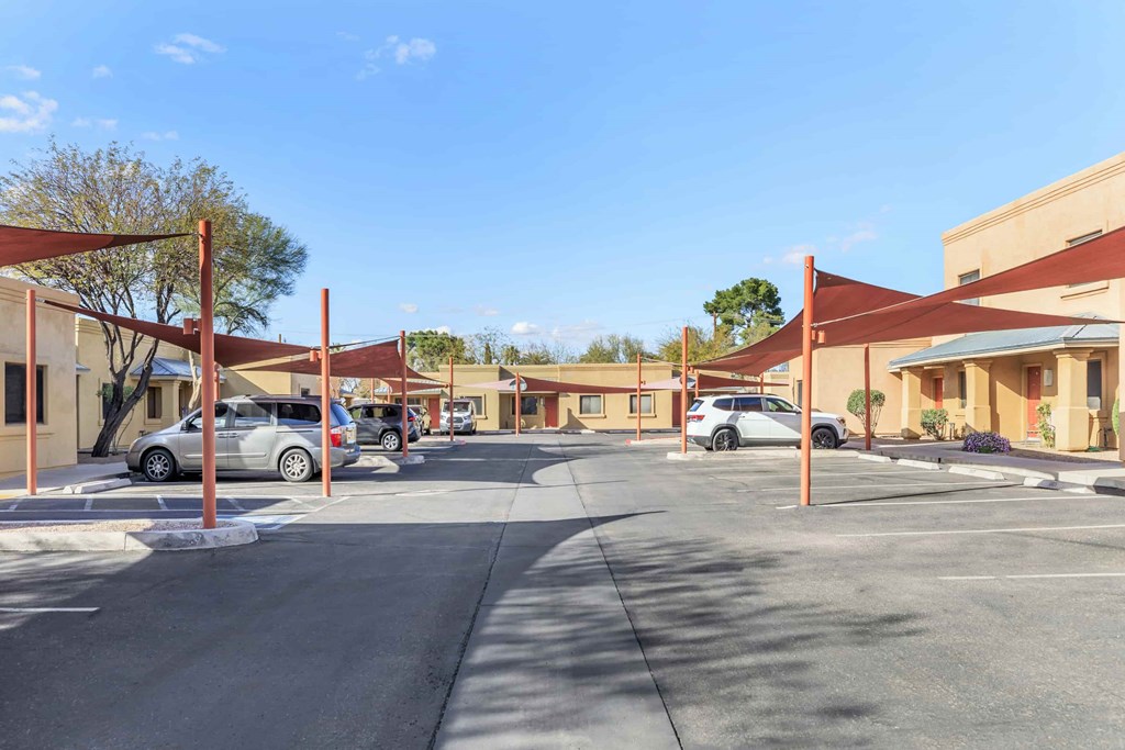 A parking lot with cars and a building in the background.