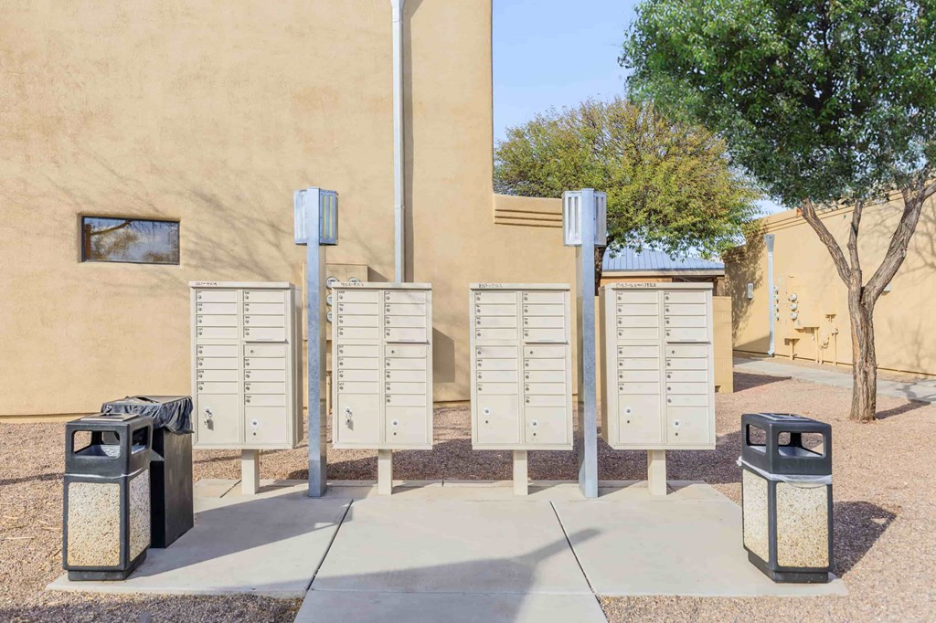 A row of mailboxes are lined up on a sidewalk.