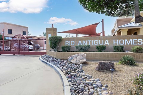 A sign that says "BIO ANTIGUA HOMES" is in front of a building.