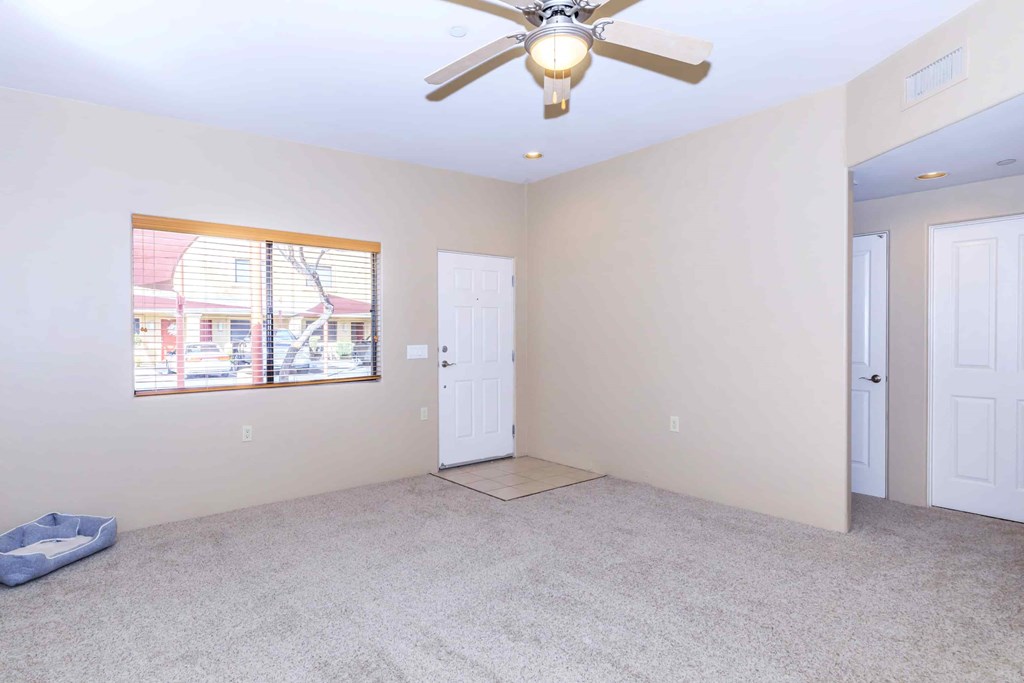 A room with a ceiling fan and two doors.