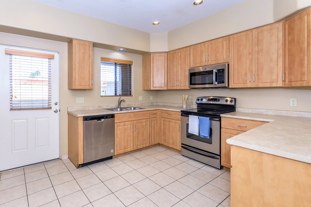 A kitchen with wooden cabinets and a black stove top oven.
