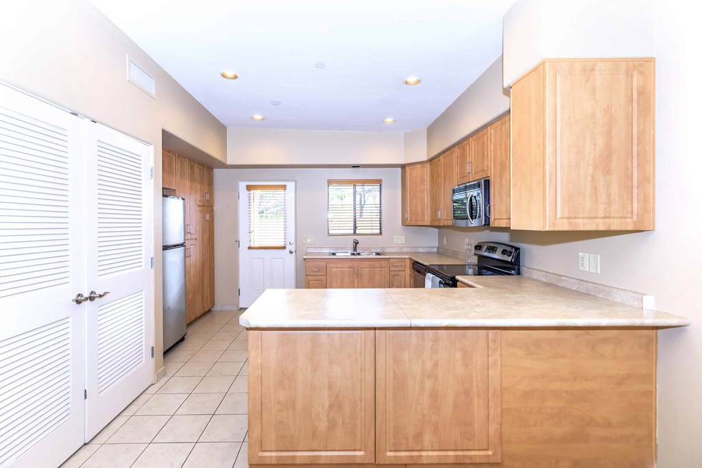 A kitchen with wooden cabinets and a white countertop.