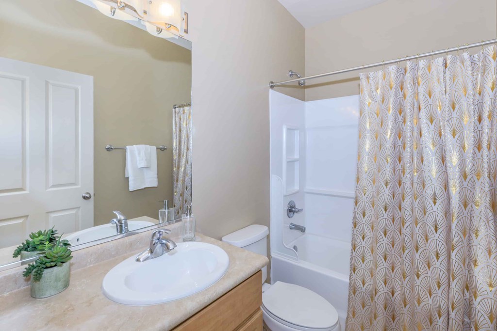 A bathroom with a sink, toilet, and shower.