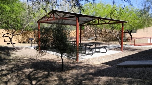 a picnic pavilion with benches in a park