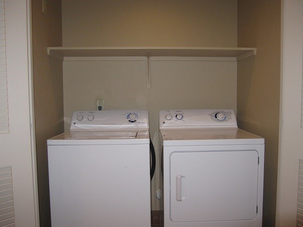 two washers and dryers in a room with a door