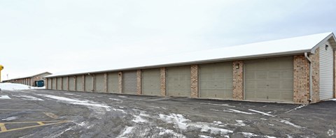 a parking lot with a building with garage doors