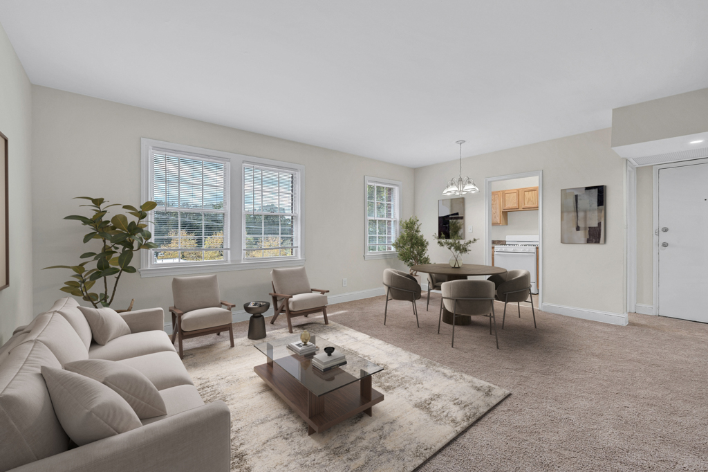 A living room with a grey couch, a coffee table, and a dining table with chairs.