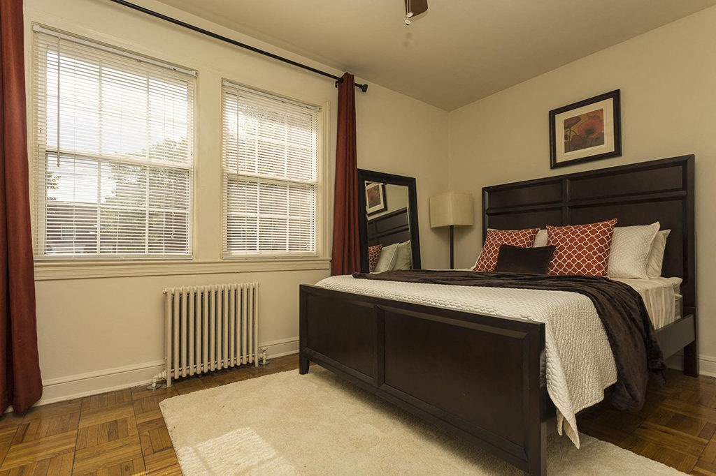 a bedroom with a bed and two windows