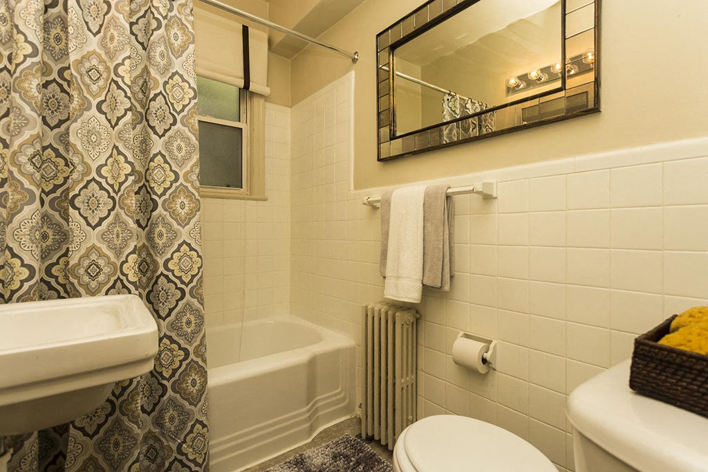 a bathroom with a white toilet and a shower curtain