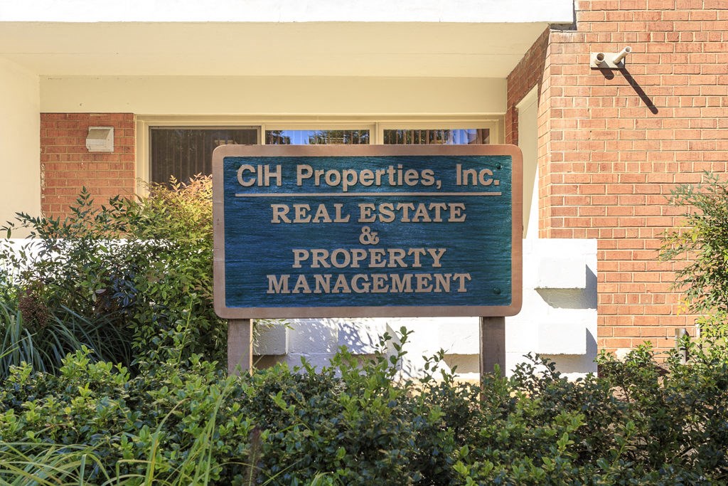 a sign in front of a building that properties real estate property