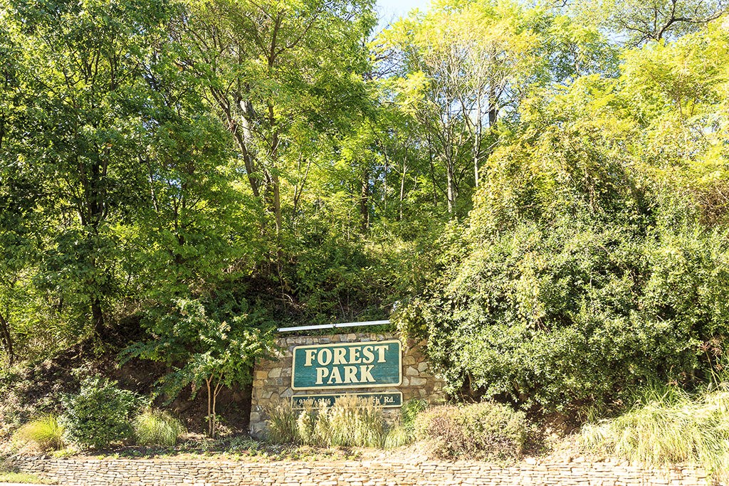 a sign for forest park in front of trees