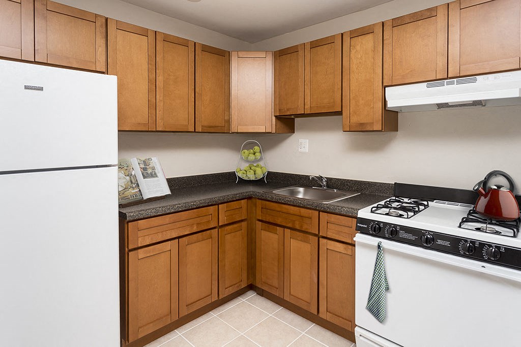 a kitchen with white appliances and wooden cabinets