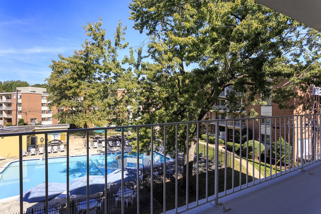 a view of a swimming pool from a balcony with a fence