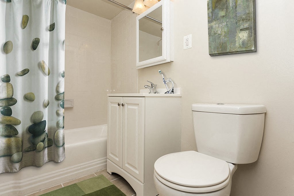 a white bathroom with a shower curtain and a toilet