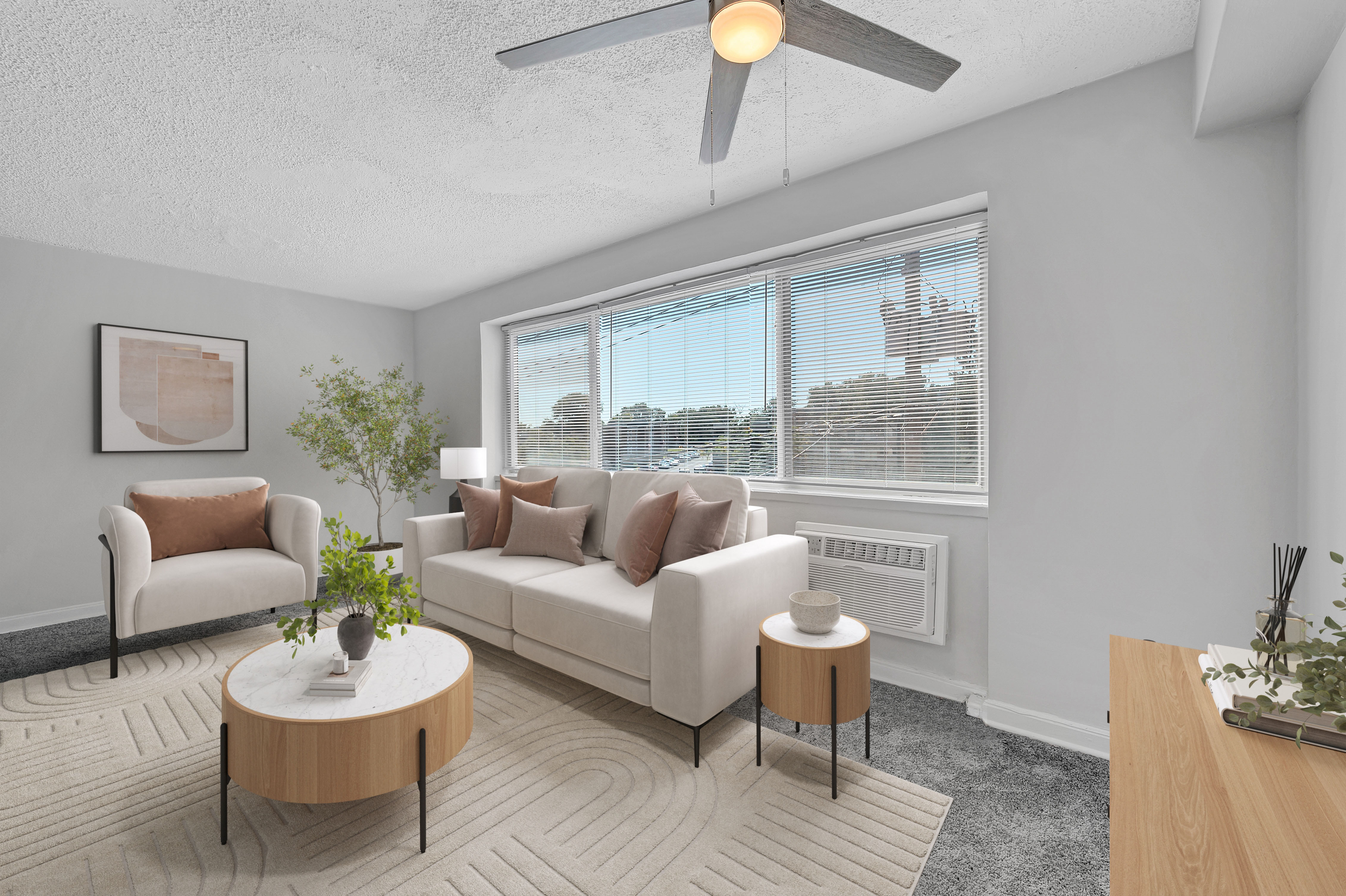 A living room with a white couch, a coffee table, and a ceiling fan.