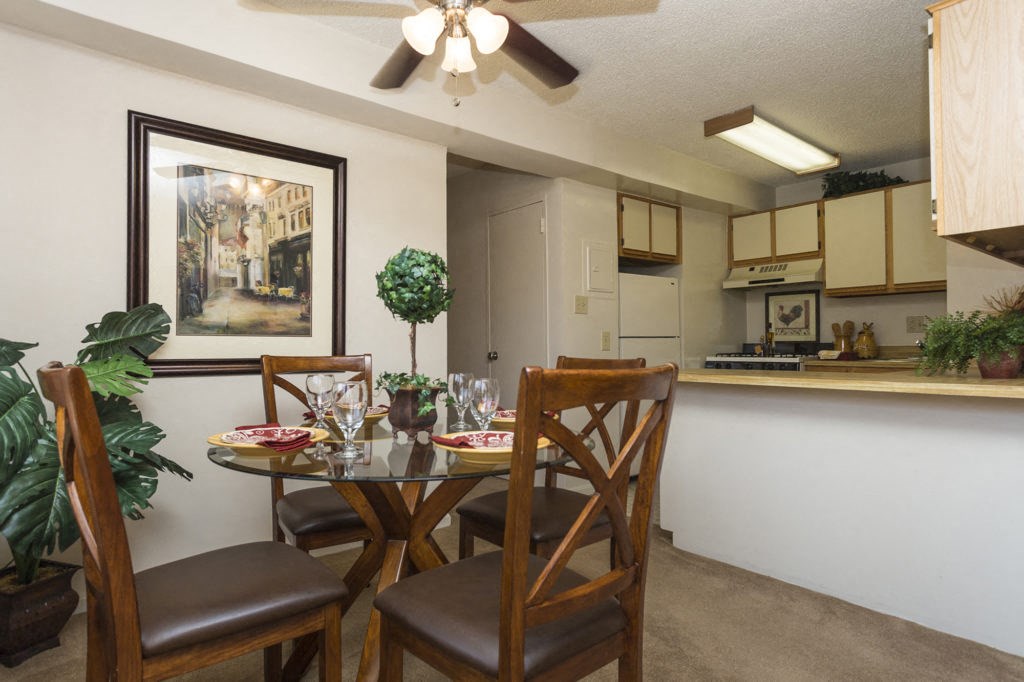 a dining room table with chairs next to a kitchen