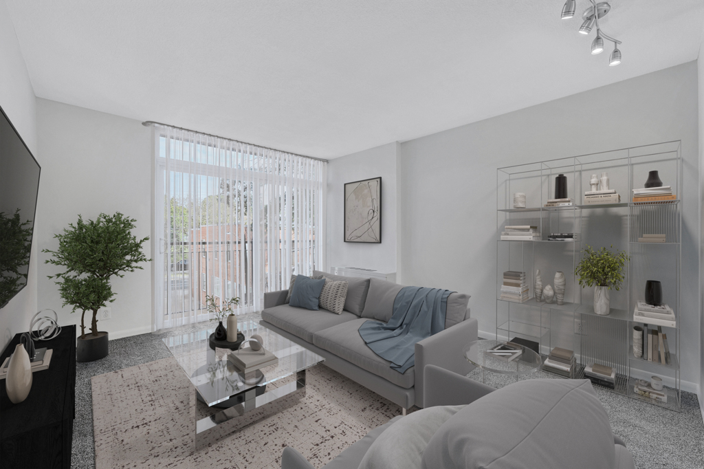 A modern living room with a grey couch, a glass coffee table, and a glass shelf with decorative items.
