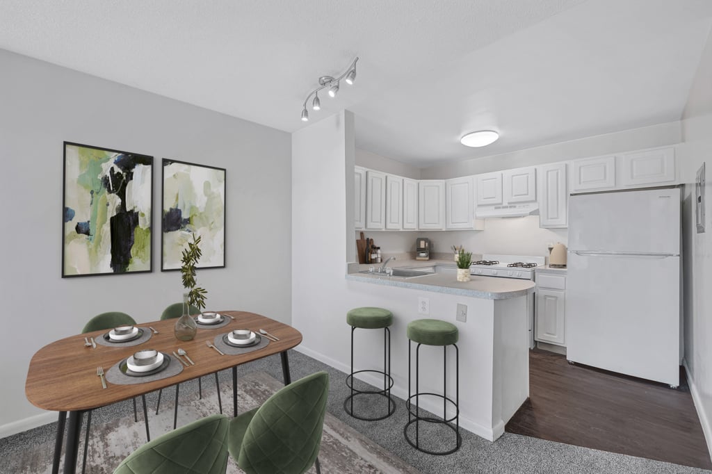 A kitchen with a table and chairs in front of it.
