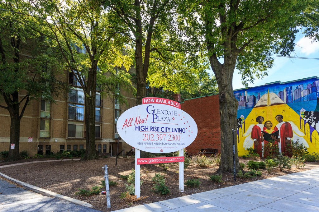 a sign in front of a building with a mural