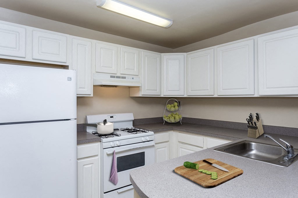 a kitchen with white cabinets and white appliances and a sink