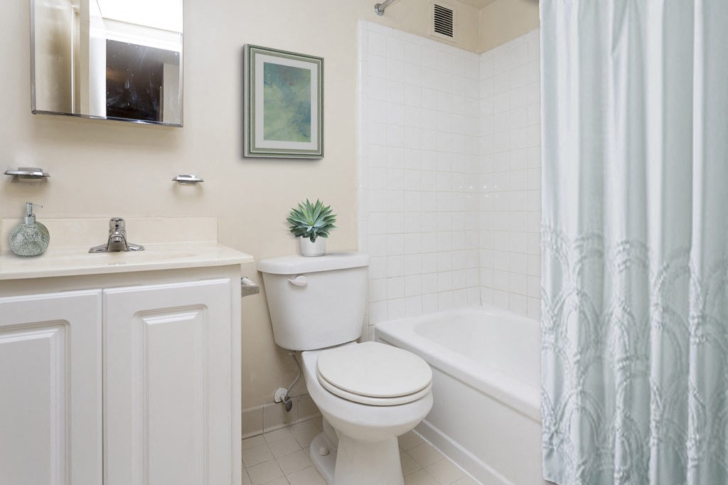 a bathroom with a toilet and a tub and a shower curtain