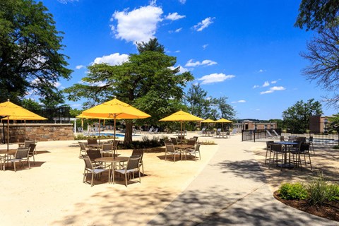 a patio with tables and chairs and umbrellas