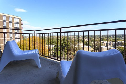 a pair of chairs on a balcony overlooking the city