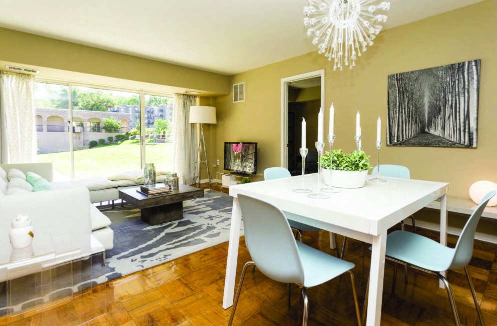 A dining room with a white table and blue chairs.