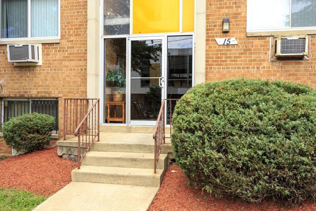 the front of a brick building with stairs and a door