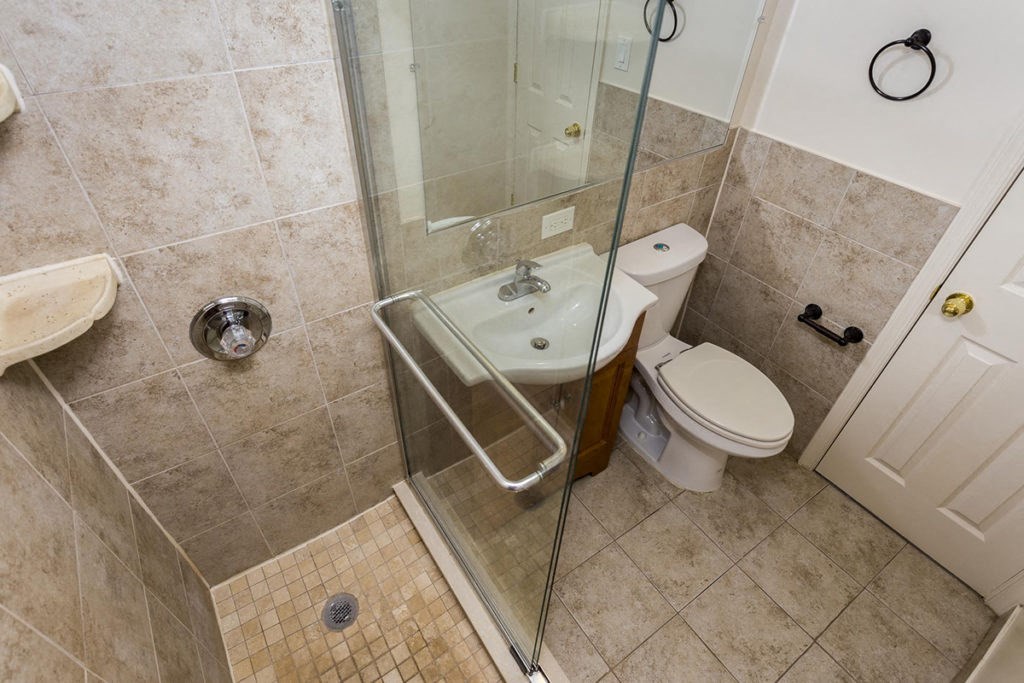 a bathroom with a shower and a toilet and a sink