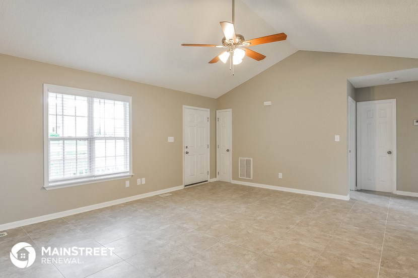 the living room of an empty house with a ceiling fan