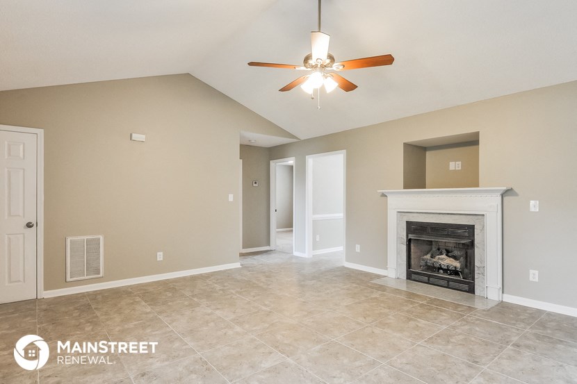 the spacious living room with fireplace and tile flooring