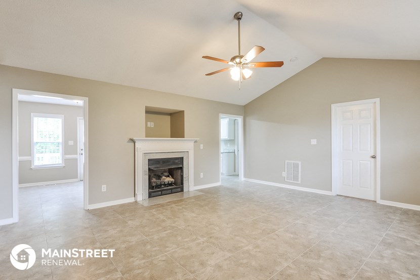 the living room with fireplace and tile flooring