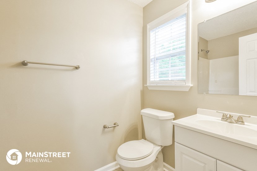 a bathroom with a toilet and a sink and a window