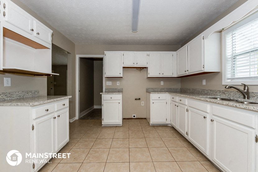 a large kitchen with white cabinets and a sink