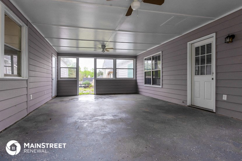 an empty garage with a white door and a ceiling fan
