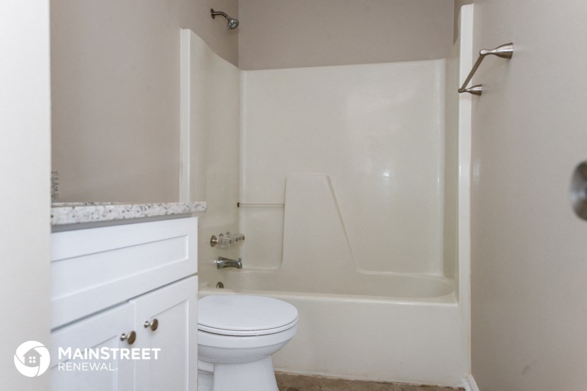 a white bathroom with a toilet and a tub