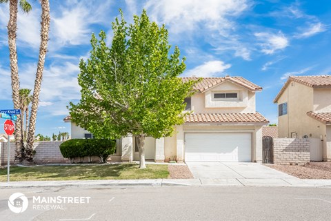 a street view of a house with a tree in front of it