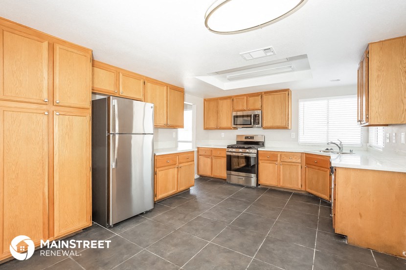 a large kitchen with wooden cabinets and stainless steel appliances