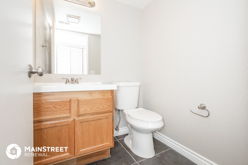 a bathroom with a toilet and a sink and a mirror