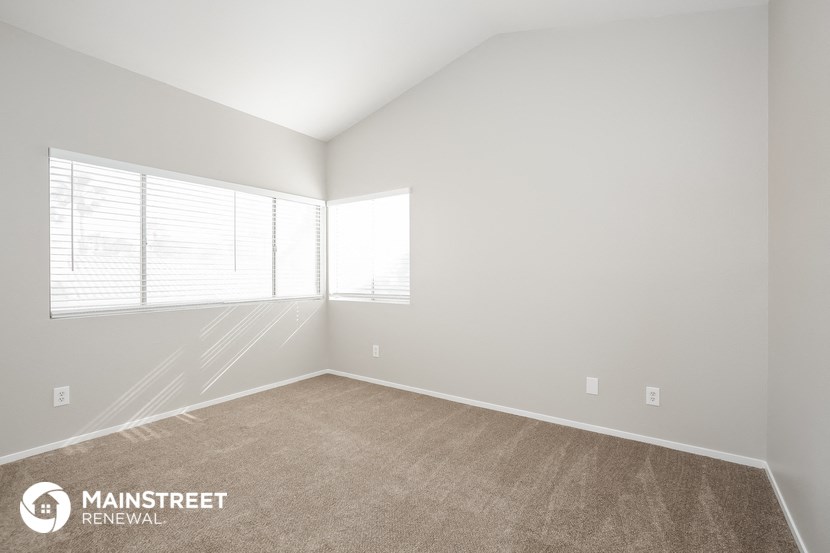 the upstairs bedroom with carpet and large windows